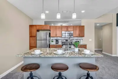 a kitchen with a large island with two bar stools at Cityview Escape • Stylish 1BR+Gym & Parking $ in Cleveland