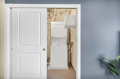 a white door leading into a kitchen with a refrigerator at Cityview Escape • Stylish 1BR+Gym & Parking $ in Cleveland
