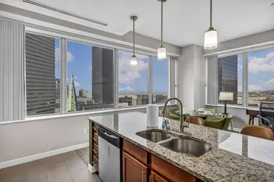 a kitchen with a view of the city from the windows at Stunning 11th Floor Corner Unit w/Amazing DT Views in Cleveland