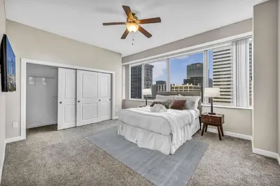 a bedroom with a bed and a large window at Stunning 11th Floor Corner Unit w/Amazing DT Views in Cleveland