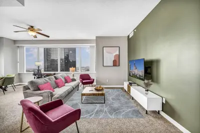a living room with a couch and chairs and a tv at Stunning 11th Floor Corner Unit w/Amazing DT Views in Cleveland