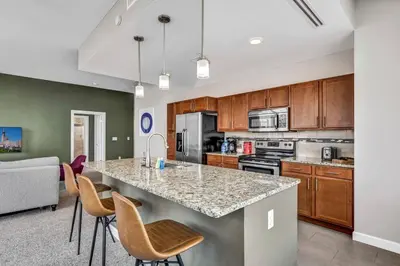a kitchen with a large island with bar chairs at Stunning 11th Floor Corner Unit w/Amazing DT Views in Cleveland