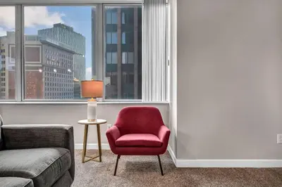 a living room with a red chair and a window at SkyTower 2BD | Parking Available | Downtown in Cleveland