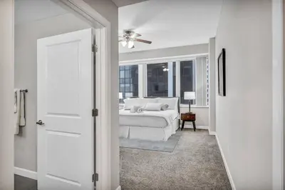 a white bedroom with a bed and a window at SkyTower 2BD | Parking Available | Downtown in Cleveland