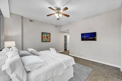 a white bedroom with a bed and a ceiling fan at SkyTower 2BD | Parking Available | Downtown in Cleveland