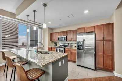 a kitchen with stainless steel appliances and wooden cabinets at Luxury High-Rise w/ City View | Paid Parking | Gym in Cleveland