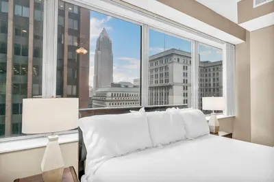 a bed in a room with a large window at Luxury High-Rise w/ City View | Paid Parking | Gym in Cleveland