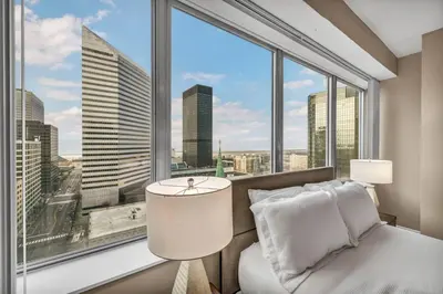 a bedroom with a bed and a large window at Luxury High-Rise w/ City View | Paid Parking | Gym in Cleveland