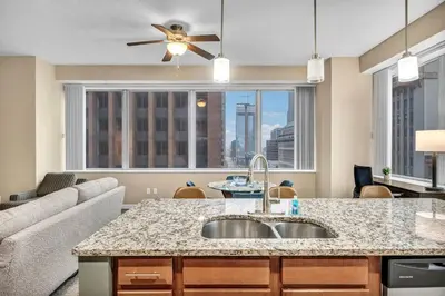 a kitchen with a sink and a living room at Luxury 13th Floor Condo: Downtown/ Parking $ /Gym in Cleveland