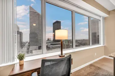 a desk with a lamp and a chair in front of a window at Luxury 13th Floor Condo: Downtown/ Parking $ /Gym in Cleveland