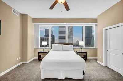 a bedroom with a large bed and a large window at Luxury 13th Floor Condo: Downtown/ Parking $ /Gym in Cleveland