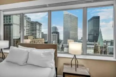 a bedroom with a large window with a view of the city at 13th Floor SkyTower: Paid Parking | Downtown | Gym in Cleveland