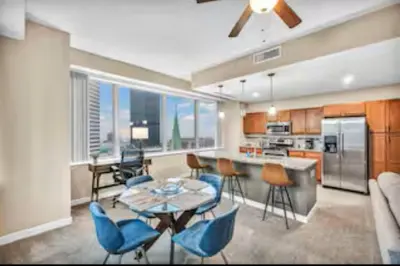 a kitchen with a table and blue chairs in a room at 13th Floor SkyTower: Paid Parking | Downtown | Gym in Cleveland