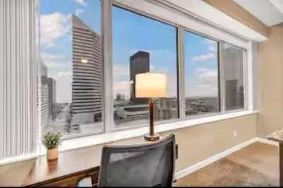 a desk with a lamp and a chair in front of a window at 13th Floor SkyTower: Paid Parking | Downtown | Gym in Cleveland
