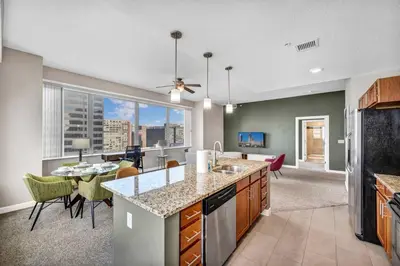 a kitchen with a counter top and a dining room at 14th Floor Lux Downtown Condo w/ LAKE VIEWS & Gym in Cleveland