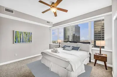 a bedroom with a large bed and a ceiling fan at 14th Floor Lux Downtown Condo w/ LAKE VIEWS & Gym in Cleveland