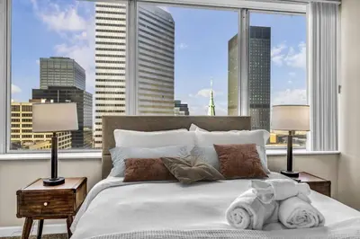 a bedroom with a bed with a view of a city at 14th Floor Lux Downtown Condo w/ LAKE VIEWS & Gym in Cleveland