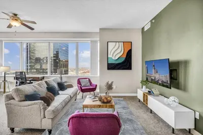 a living room with a couch and a table at 14th Floor Lux Downtown Condo w/ LAKE VIEWS & Gym in Cleveland