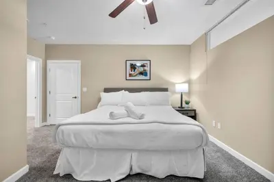a bedroom with a large white bed with a ceiling fan at Luxury High-Rise • 18th Floor Condo • Parking $ in Cleveland