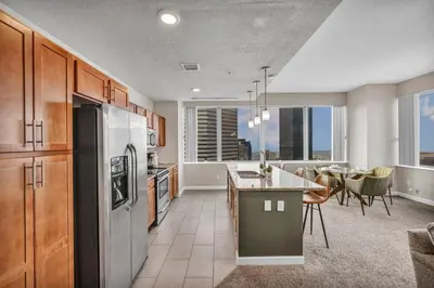 a kitchen with a refrigerator and a table with chairs at Luxury 21st Floor Penthouse | Great Downtown VIEWS in Cleveland