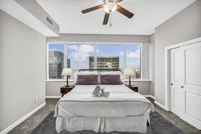 a bedroom with a bed and a large window at Luxury 21st Floor Penthouse | Great Downtown VIEWS in Cleveland