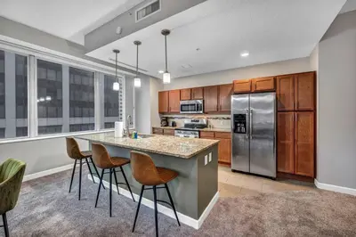 a kitchen with a large island with bar stools at HUGE Panoramic SkySuite w/ Downtown VIEWS: Gym in Cleveland