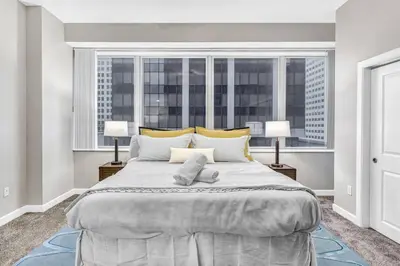 a large bed in a room with a large window at HUGE Panoramic SkySuite w/ Downtown VIEWS: Gym in Cleveland