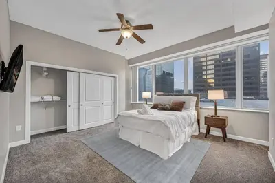 a bedroom with a bed and a ceiling fan at HUGE Panoramic SkySuite w/ Downtown VIEWS: Gym in Cleveland