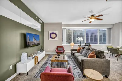 a living room with a couch and a table at HUGE Panoramic SkySuite w/ Downtown VIEWS: Gym in Cleveland