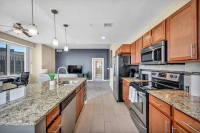 a kitchen with wooden cabinets and granite counter tops at LAKE VIEW SkyTower Suite: Downtown ~ King Bed in Cleveland