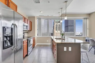 a kitchen with a stainless steel refrigerator at LAKE VIEW SkyTower Suite: Downtown ~ King Bed in Cleveland