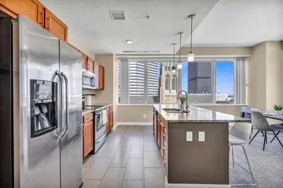 a kitchen with a stainless steel refrigerator at LAKE VIEW SkyTower Suite: Downtown ~ King Bed in Cleveland