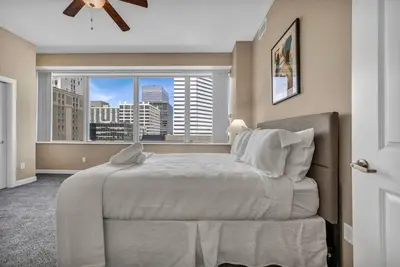 a bedroom with a large bed and a window at LAKE VIEW SkyTower Suite: Downtown ~ King Bed in Cleveland
