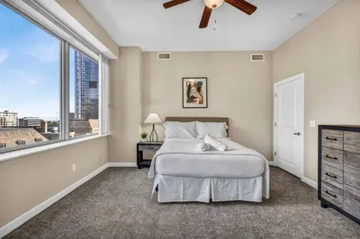 a bedroom with a bed and a large window at LAKE VIEW SkyTower Suite: Downtown ~ King Bed in Cleveland