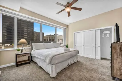 a bedroom with a large bed and a ceiling fan at LAKE VIEW SkyTower Suite: Downtown ~ King Bed in Cleveland