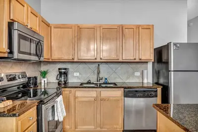 a kitchen with wooden cabinets and stainless steel appliances at Epic Downtown Pad • Entertain & Unwind in Cleveland