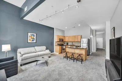 a living room with a couch and a kitchen at Epic Downtown Pad • Entertain & Unwind in Cleveland