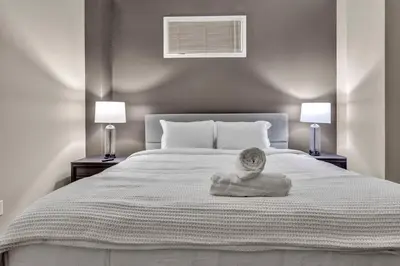 a bedroom with a large white bed with two lamps at The Playhouse Suites 1BD | Parking | Downtown in Cleveland