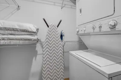 a white kitchen with a striped tie on a refrigerator at The Playhouse Suites 1BD | Parking | Downtown in Cleveland