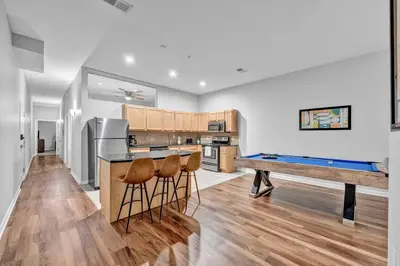 a kitchen with a bar with stools and a pool table at Comfy City Vibe • Theater District Gem in Cleveland