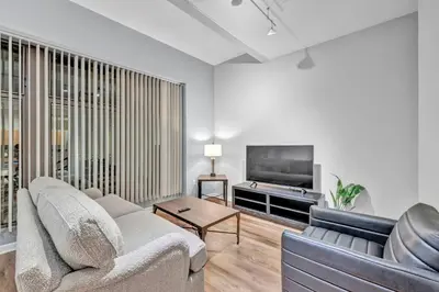 a living room with a couch and a flat screen tv at Comfy City Vibe • Theater District Gem in Cleveland