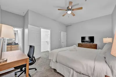 a bedroom with a bed and a desk and a ceiling fan at Comfy City Vibe • Theater District Gem in Cleveland