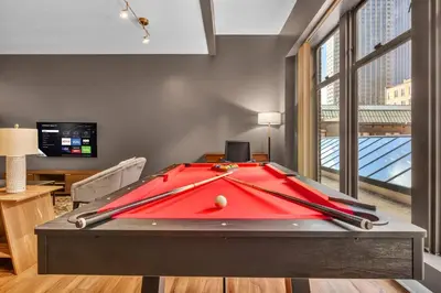 a pool table in a living room with a red cover at Playhouse Square Flat • Pool Table in Cleveland