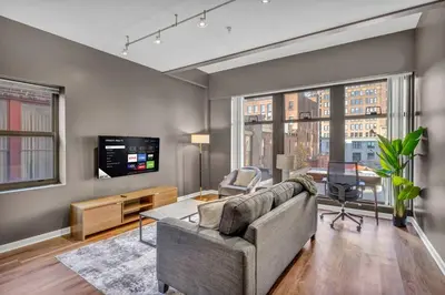 a living room with a couch and a tv at Playhouse Square Condo | Parking | Downtown in Cleveland