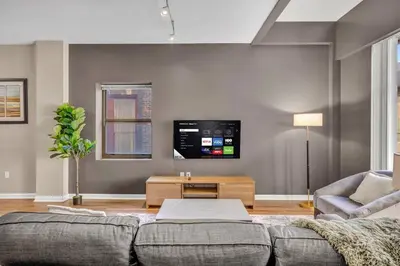 a living room with a couch and a flat screen tv at Playhouse Square Condo | Parking | Downtown in Cleveland