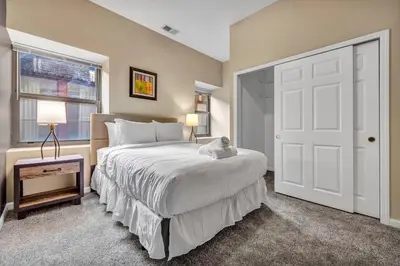 a bedroom with a white bed and a window at Playhouse Square Condo | Parking | Downtown in Cleveland
