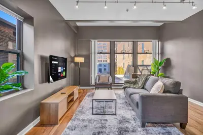 a living room with a couch and a tv at Playhouse Square Condo | Parking | Downtown in Cleveland