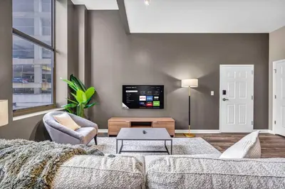 a living room with a couch and a tv at Charming Flat in Amazing Location | Parking in Cleveland