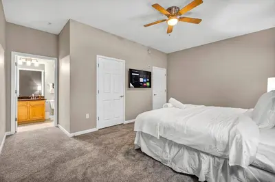 a bedroom with a white bed and a ceiling fan at HUGE Luxe Downtown Flat: Pool Table & Parking in Cleveland