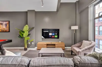 a living room with a couch and a tv at HUGE Luxe Downtown Flat: Pool Table & Parking in Cleveland